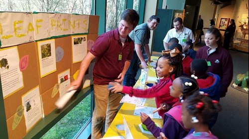 students with exhibitor at stem leaves and trees at the mississippi museum of natural science