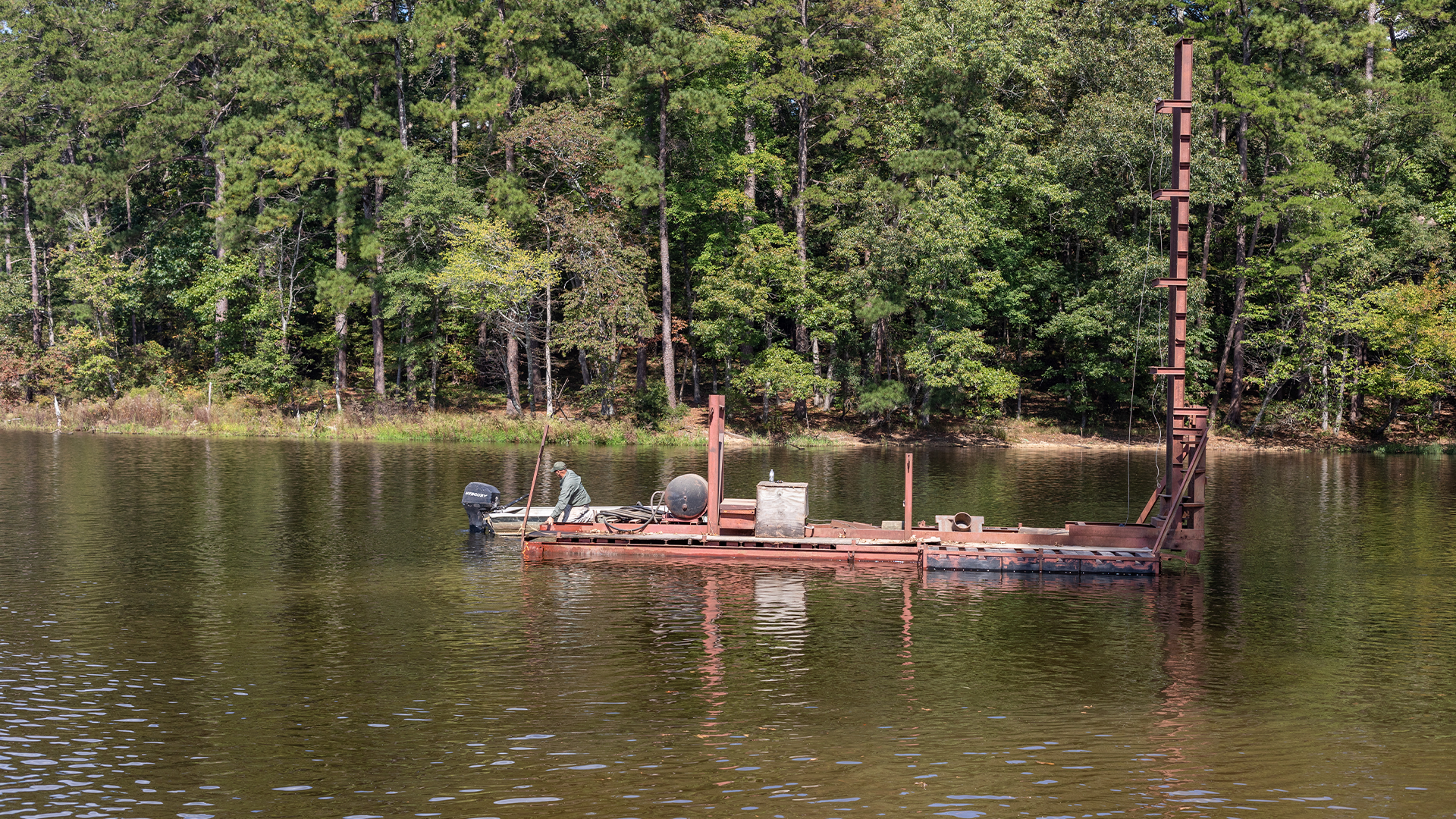 pile-driving barge being used on a lake