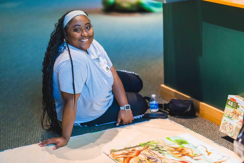 Museum volunteer with fossil art at Fossil Road Show